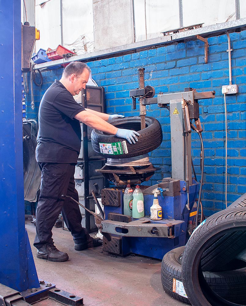 Mechanic putting new tyre on a wheel